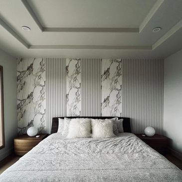 Minimalist bedroom with a large bed and modern decor near a large window.