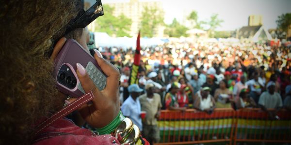 Woman on phone at crowded outdoor event.