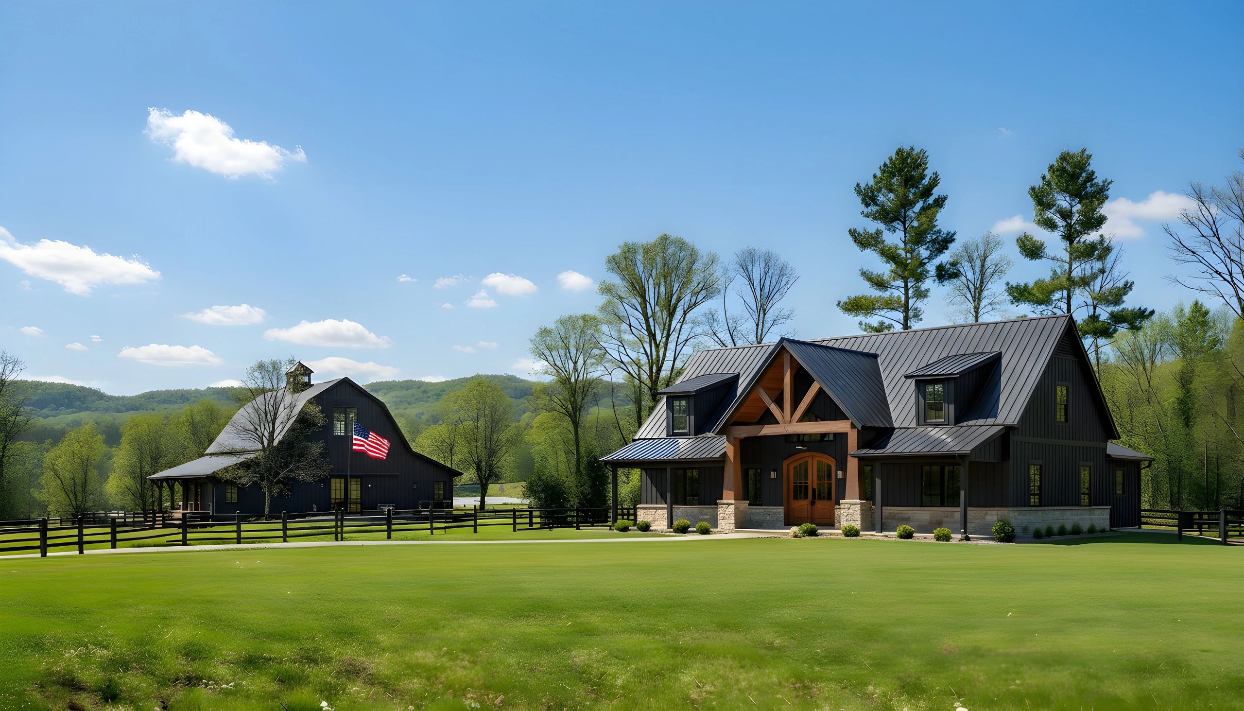 Two rustic black buildings with pitched roofs on a lush green lawn under a clear sky.