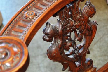 Intricately carved wooden furniture detail with floral and scroll designs.
