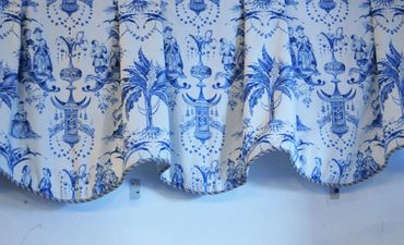 Blue and white patterned fabric with intricate designs and scalloped edges.