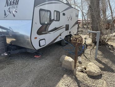 Camping trailer setup in a wooded area.