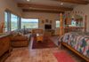 The studio living/bedroom space viewed from the bathroom door.  Navajo sand paintings and other art, express Native American culture of the region.