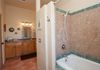 Spacious bathroom with tile throughout and soaker tub/shower with lots of ledge space for your bathing necessities.