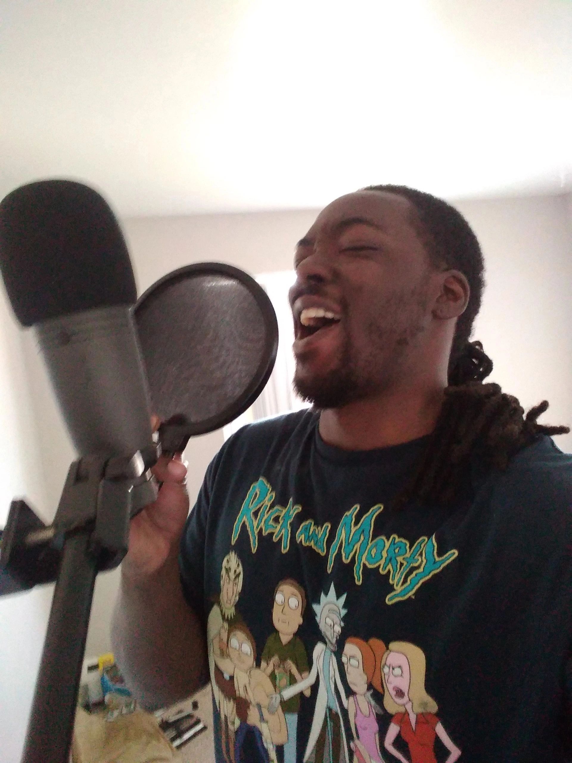 The musician DopeAMean is Rapping Lyrics On The Microphone, at his home studio in Aurora, Colorado.