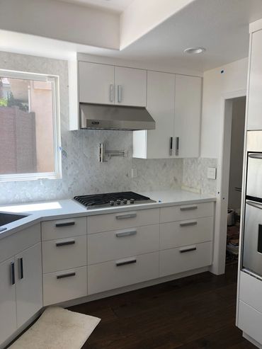 Kitchen with white cabinets, quartz countertops, stainless steel sink and appliances