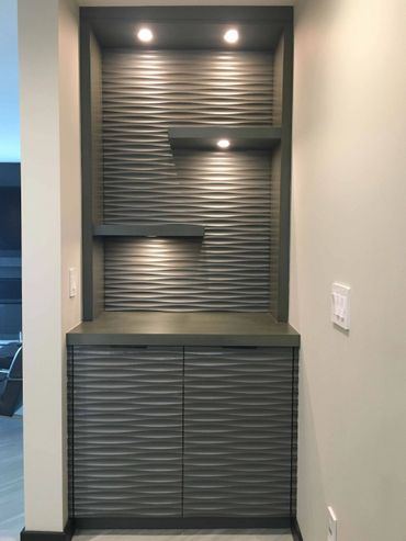 Small custom dark cabinet in a niche with open shelving and LED lighting