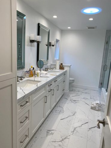 White bathroom with white cabinets and quartz counter top.