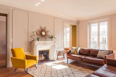 Living room with light color walls/trim, white crown molding, and ornate fireplace