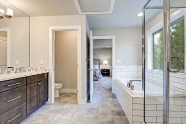 Beautiful white shower with brown cabinets and shower with glass enclosure