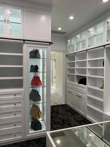 Custom white cabinet with glass doors above, open shelving, and lower drawers
