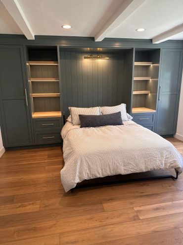 Beautiful wall to wall cabinets with doors and drawers, open shelving, and Murphy bed.