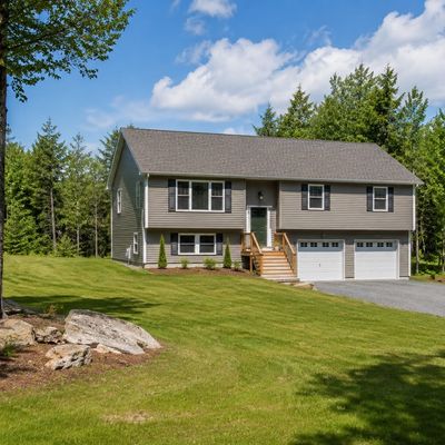 Suburban two-story house with double garage and green lawn.