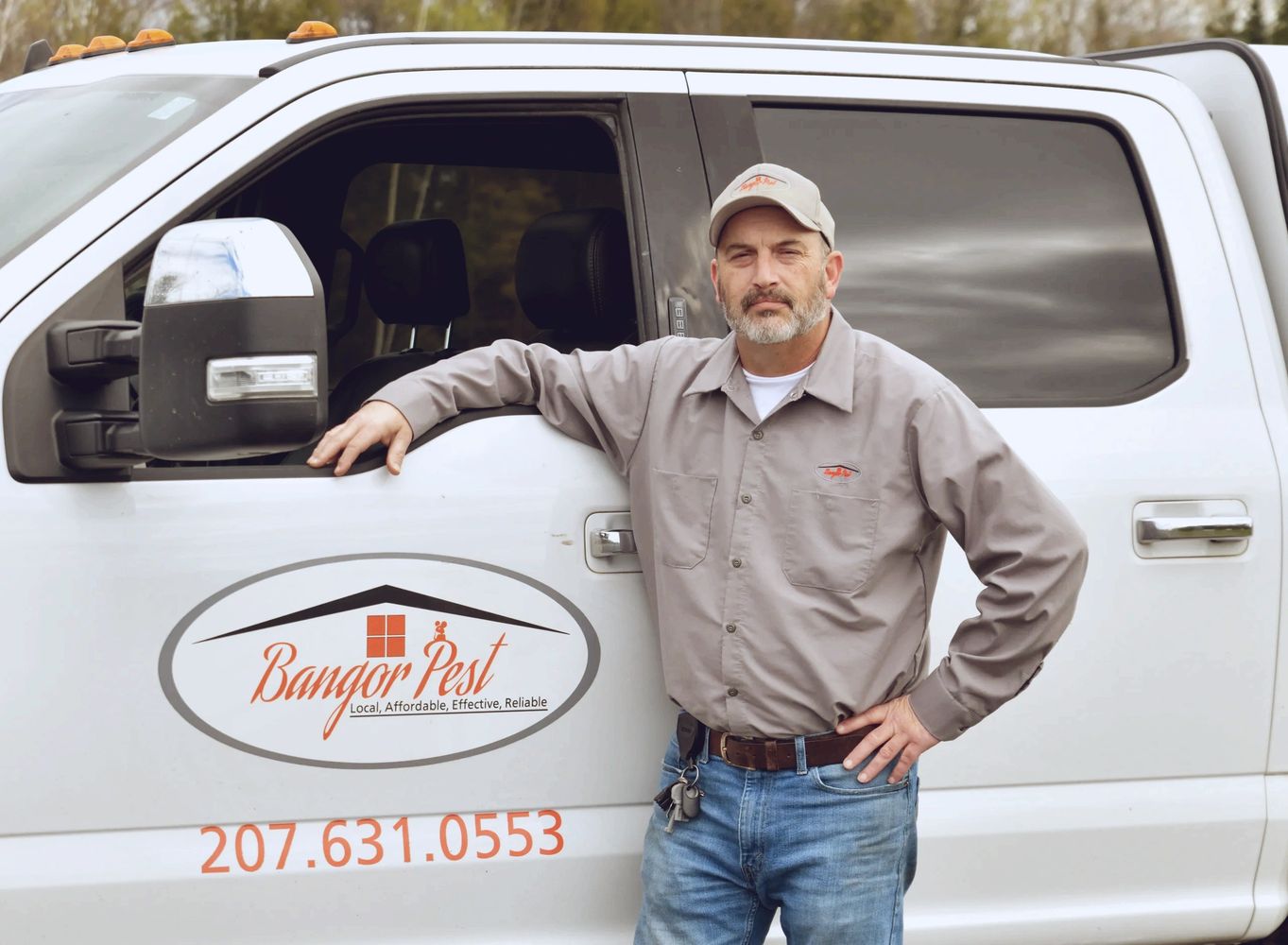 Pest control worker standing next to Bangor Pest truck.