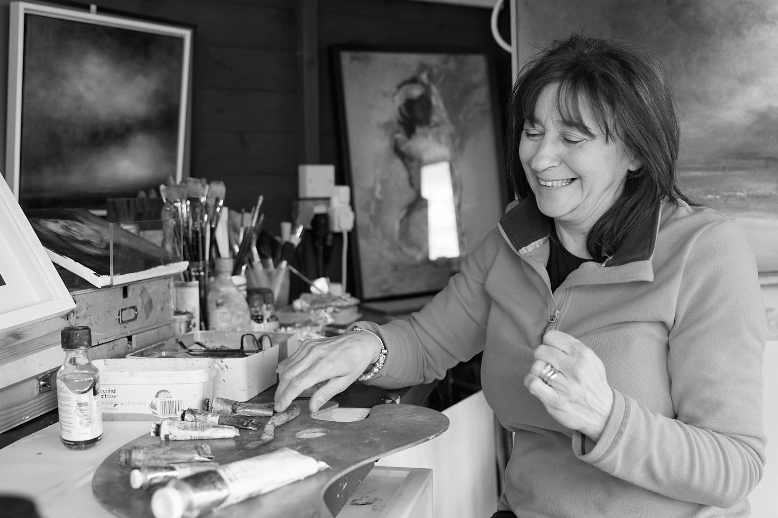 Laura in her studio, mixing oil paint the palatte