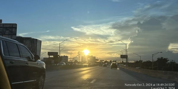 Sunset over a busy highway with cars heading home.