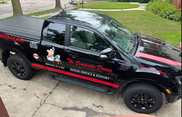 Black pickup truck advertising a computer repair service.