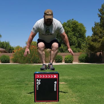 Man performing a box jump onto a 20-inch box outdoors.