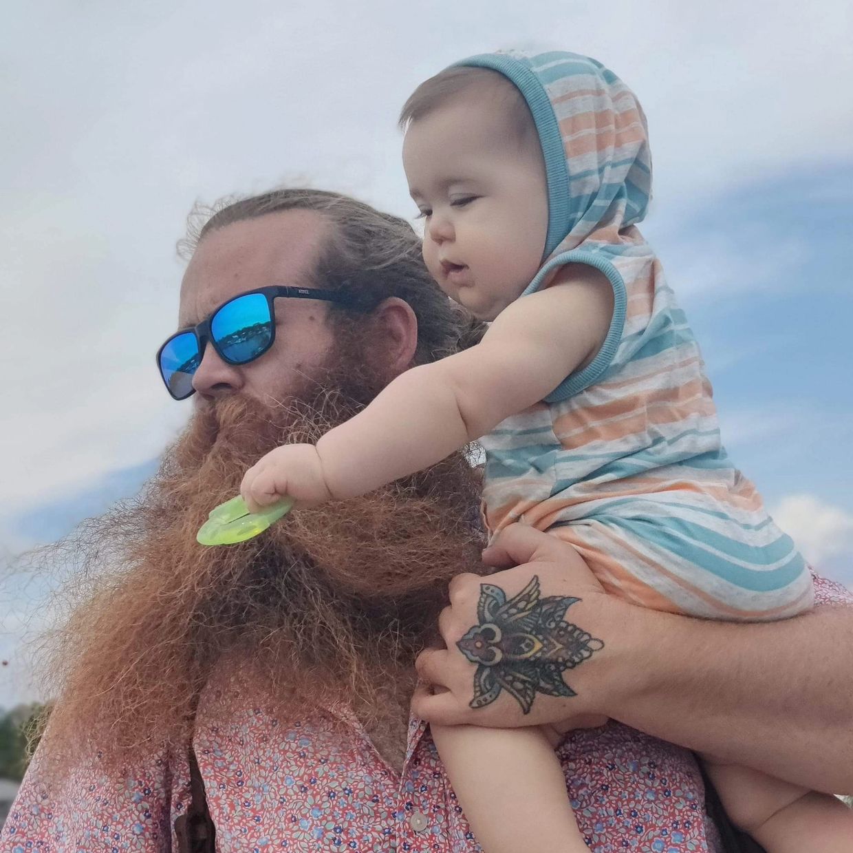 Man with big beard holding baby.