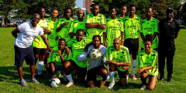 A soccer team posing on a grassy field in bright green jerseys.