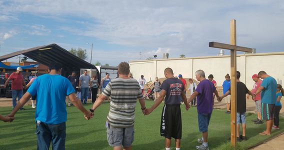 People standing in a circle with a crucifix