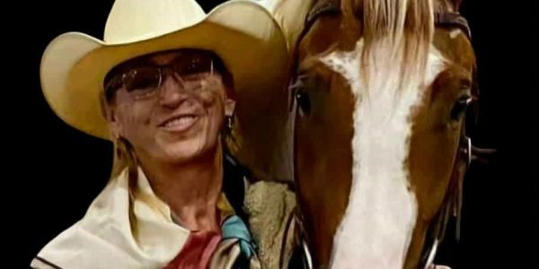 Person wearing a cowboy hat with a horse.