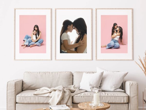 Three framed photos of mother and daughter displayed above a beige sofa in a cozy living room.