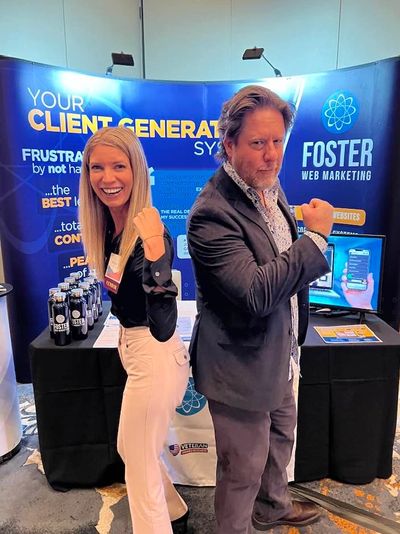 Two professionals posing back-to-back at a Foster Web Marketing booth.