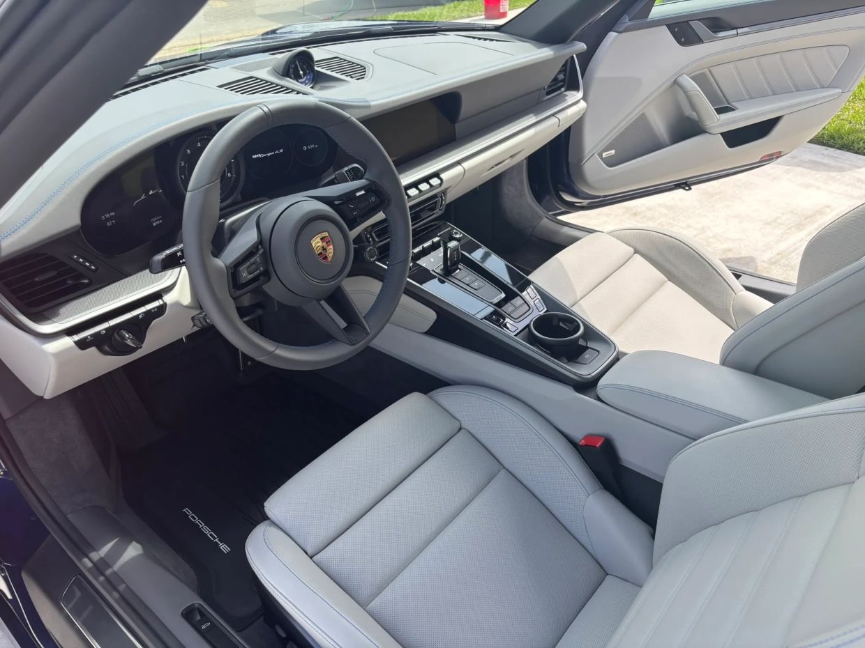 Luxurious Porsche car interior with white seats.