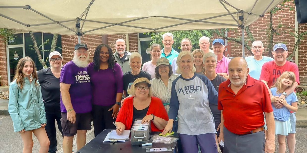 Group of diverse people smiling under a canopy outdoors.