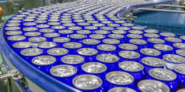 Blue cans moving on a conveyor belt in a factory.