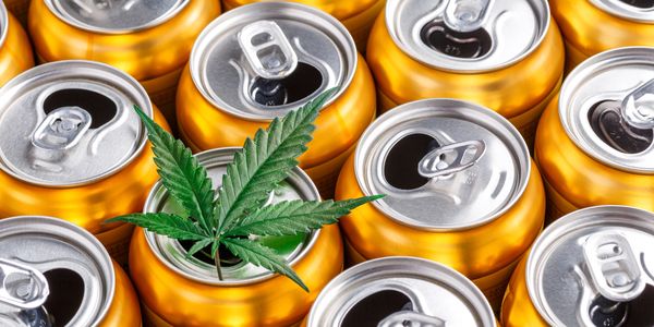Golden cans with a green cannabis leaf on top of one can.