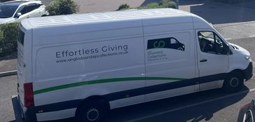 A white delivery van with green stripes and charity branding.