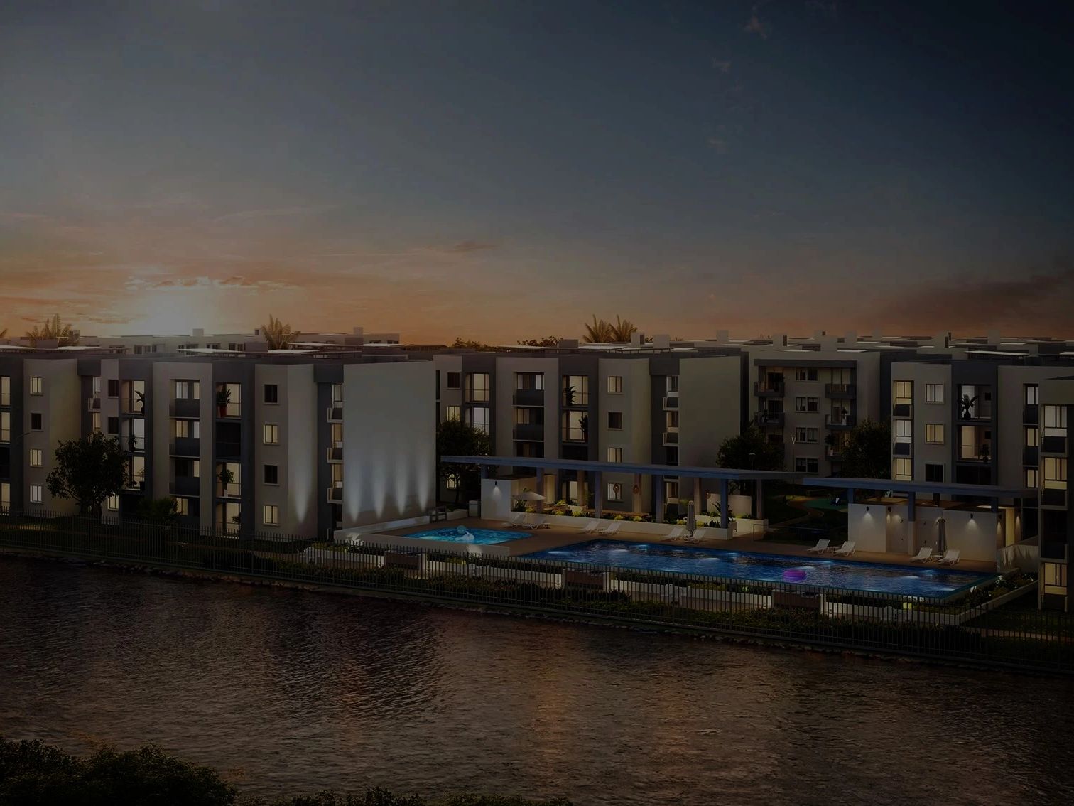 Complejo residencial moderno con piscina al atardecer.