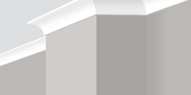Close-up of white crown molding on a gray wall corner.