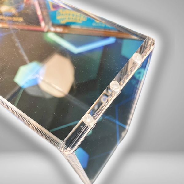 Close-up of a clear, geometric prism reflecting colorful lights.