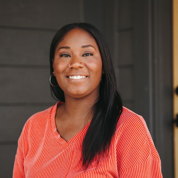Smiling woman in a red striped shirt with hoop earrings.