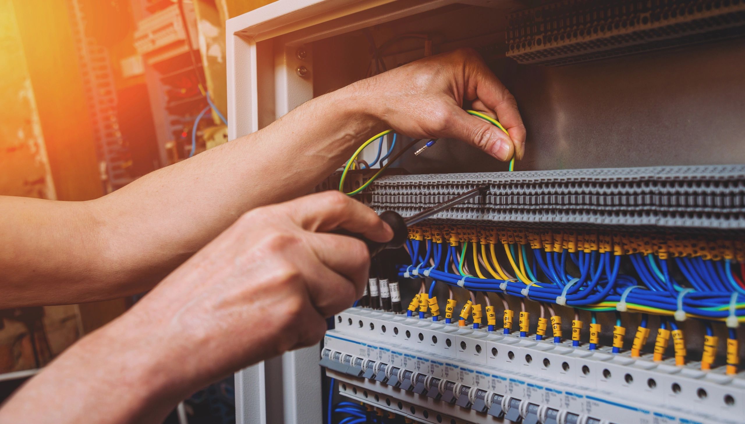 The man is repairing the switchboard voltage with automatic switches. 