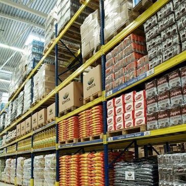 Warehouse shelves stacked with packaged goods and boxes.
