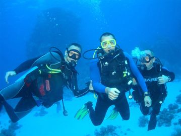 Three scuba divers underwater exploring the ocean.