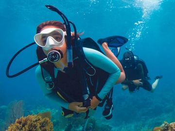 Two scuba divers exploring vibrant underwater coral reefs.