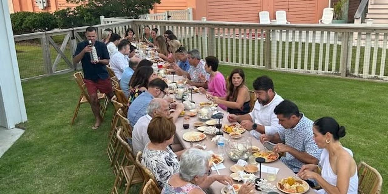 Large group enjoying an outdoor meal together.