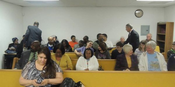 People seated in a waiting room or meeting area.