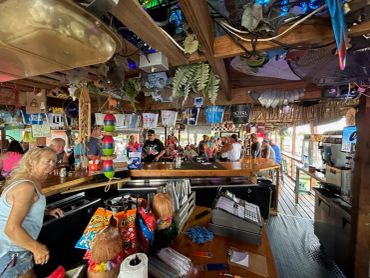 A lively bar scene with people enjoying drinks and conversation indoors.