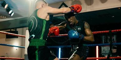 Two boxers engaged in an intense match inside a boxing ring.