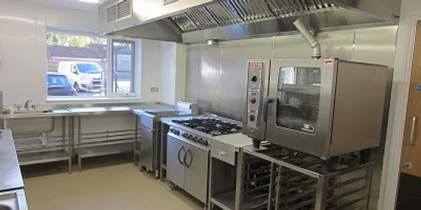 Commercial kitchen newly installed in a care home with combination oven, six burner range and sink