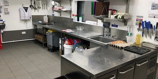 Inside the commercial kitchen of Finnegans Fish & Chips Shop with stainless steel tabling