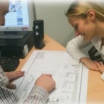 A client of RACS Ltd being shown their commercial kitchen layout design on an office table