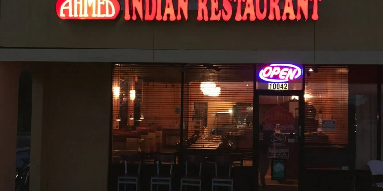 Ahmed Indian Restaurant storefront with illuminated sign and open neon light.