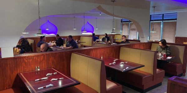 Cozy restaurant booths with warm lighting and blue accent lights.